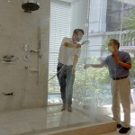 新業(yè)建設(shè)卓勝隆董事長（右）伸手測試三段式水流變化為肌膚帶來的觸感，親身體驗，精選出舒心的衛(wèi)浴設(shè)備。