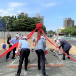新業(yè)建設 穆椿松名譽董事長(右一)帶領新業(yè)團隊以金鏟鏟起沙堆，象徵工程進度順利，動土開工大吉大利！