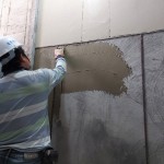 除了事先調和抿石子，先於泥作打底面上抹上一層黏著劑，使抿石子與牆面緊密貼合。