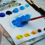 飽和多彩的顏料，在紙製調(diào)色盤(pán)上，用畫(huà)筆輕輕均勻塗開(kāi)，準(zhǔn)備在素色畫(huà)布上恣意揮灑。