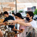 從攤販?zhǔn)种薪舆^最適合午後享用的輕食，攤販同時將心意以雙手一同遞上，彼此的這份互動是盛夏美好的一景。