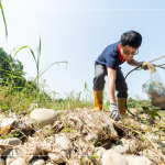 從石縫中抽出韌性的橡膠圈，岸邊的垃圾也不可輕忽，可能會(huì)因?yàn)闈q潮後的潮水而沖刷到溪裡。