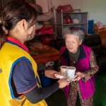 「阿嬤呷飯囉!」，甘霖基金會志工將便當(dāng)送到獨居長輩手中的同時，也不忘送上一兩句暖心的問候。