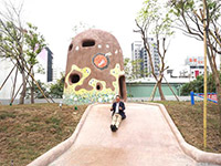 新業(yè)建設(shè)董事長卓勝隆童心大發(fā)，在碉堡地景溜滑梯。