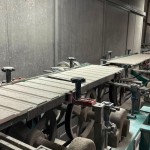 乾燥處理過的磁磚，整齊地陳列在輸送臺上，準備進入下一道逐層施釉的工序。