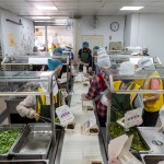 清晨六點半，廚房內(nèi)的志工開始各就各位，前處理區(qū)、烹調(diào)區(qū)、備餐區(qū)等，我們也站在輸送臺旁、各自的崗位上，依照各長輩的飲食需求配膳及調(diào)整菜量，與時間賽跑，好讓每天熱騰騰的飯包準(zhǔn)時送達(dá)。